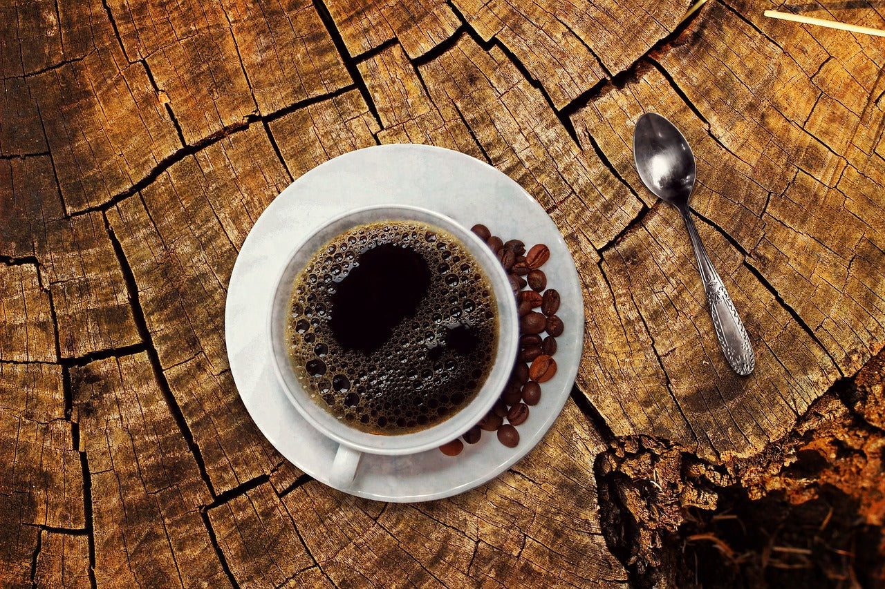 Regalos para amantes del caf&eacute; con taza y granos sobre madera