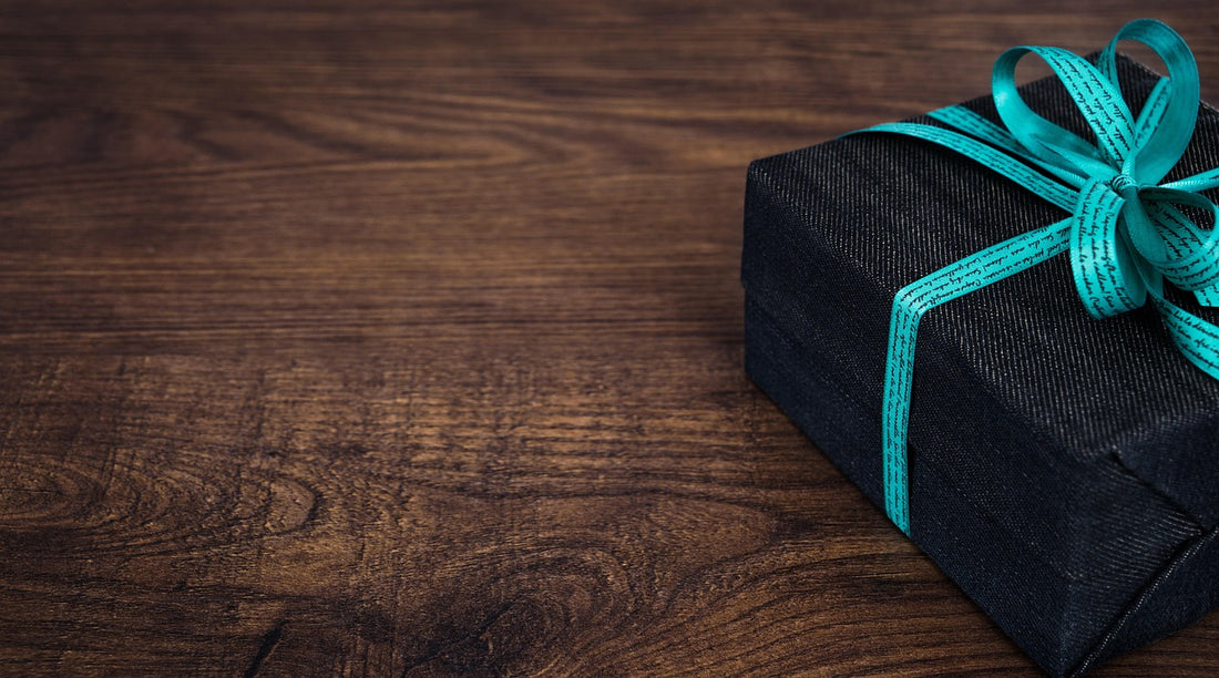Caja de regalo con lazo sobre madera, ideal como regalo de cumpleaños original