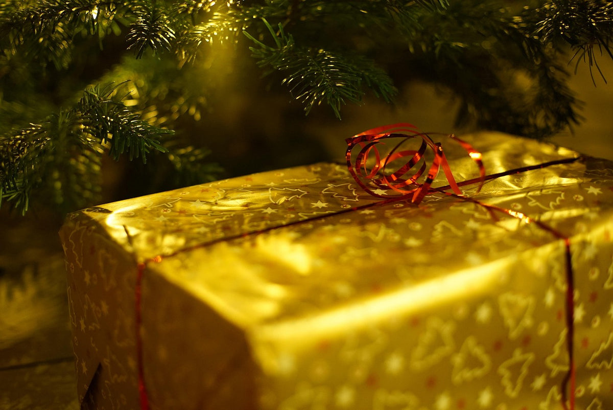 Regalo envuelto bajo el árbol de Navidad para el amigo invisible